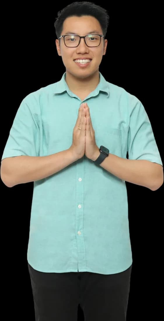 Raymond smiling with his hands pressed together in greeting