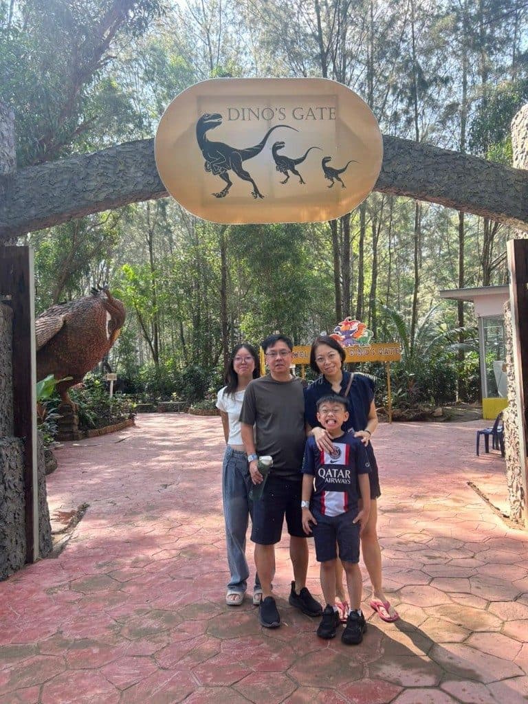 A family of four under the stone Dino's Gate arch