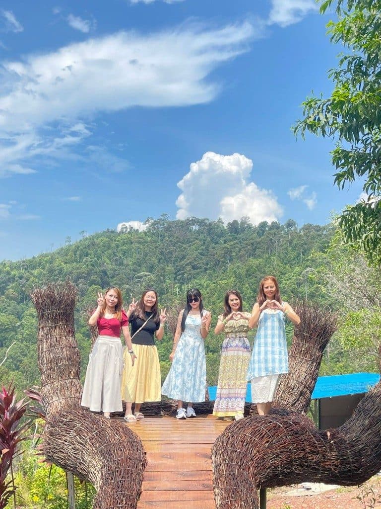 Guests standing inside a giant woven hand sculpture above the Batam hills
