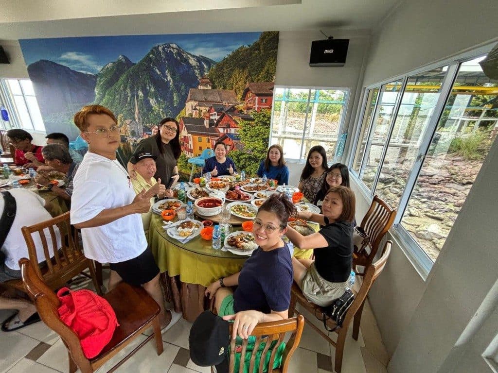 A large group around a dinner table covered in seafood dishes in Batam